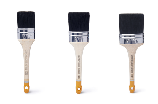 Three ICR Champagne flat oval brushes in graduated sizes with black bristles and wood handles with gold tips